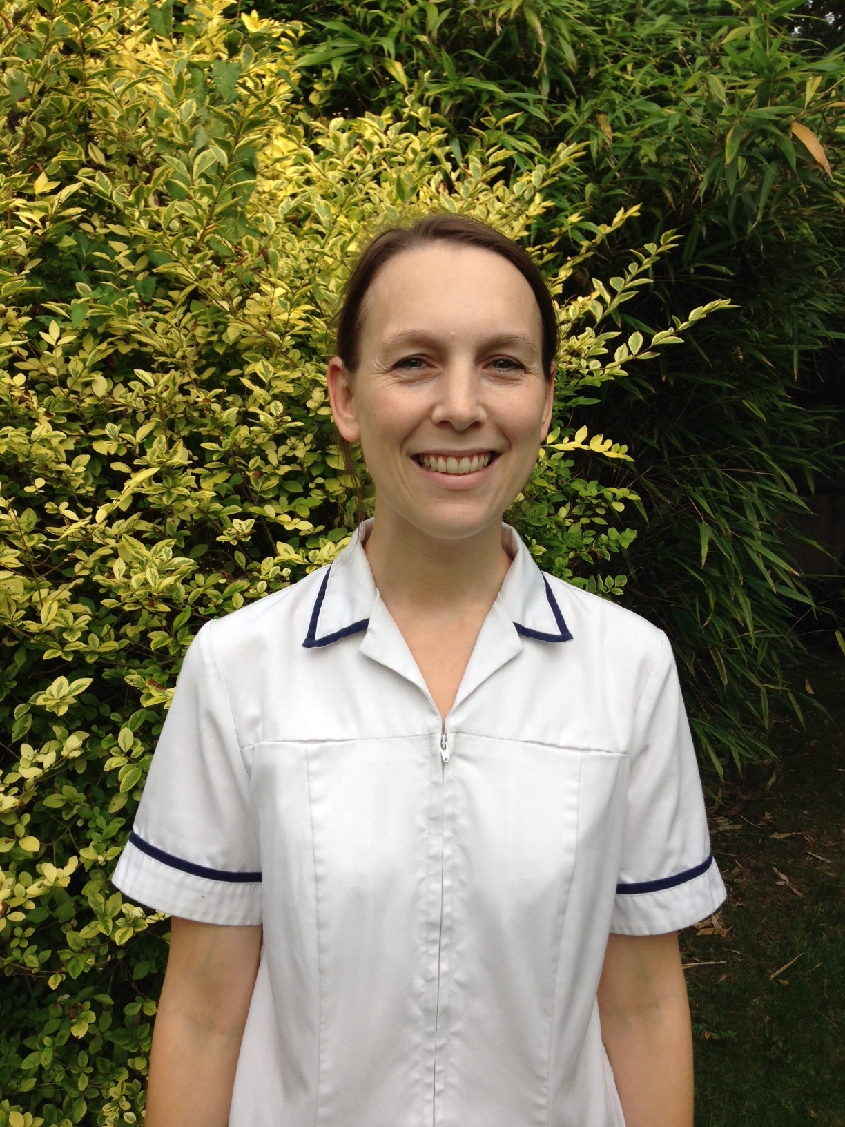 Louise Hammond, chartered physiotherapist, in a white clinical tunic